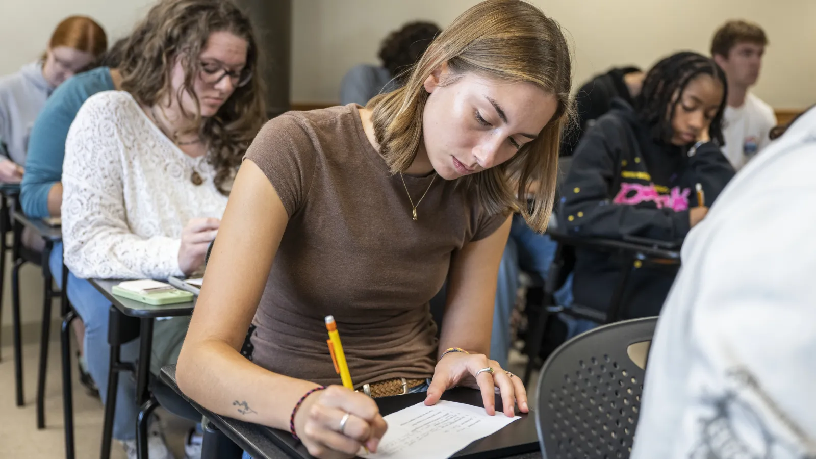 Students in class writing on paper