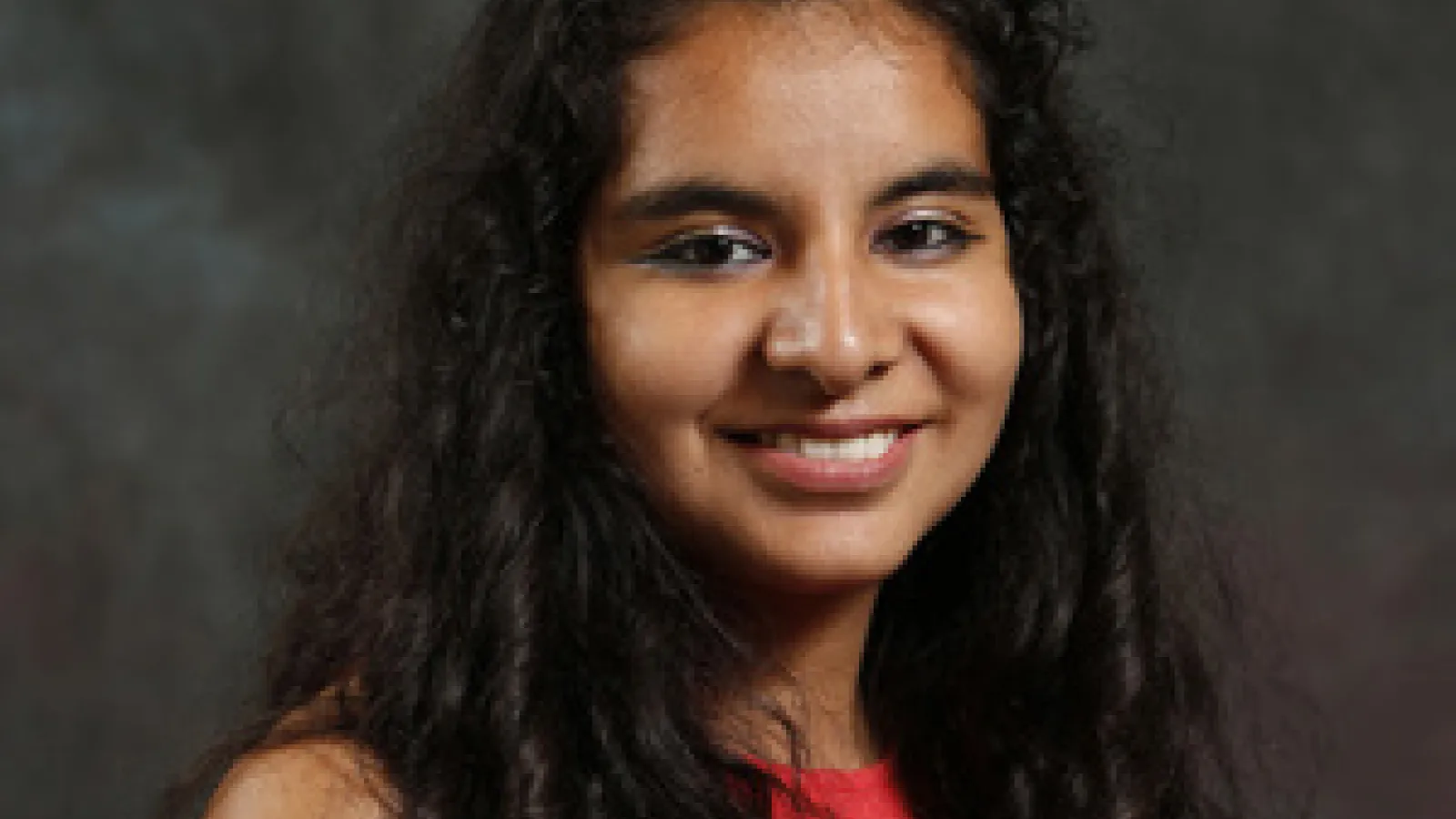Female graduate student smiles at camera