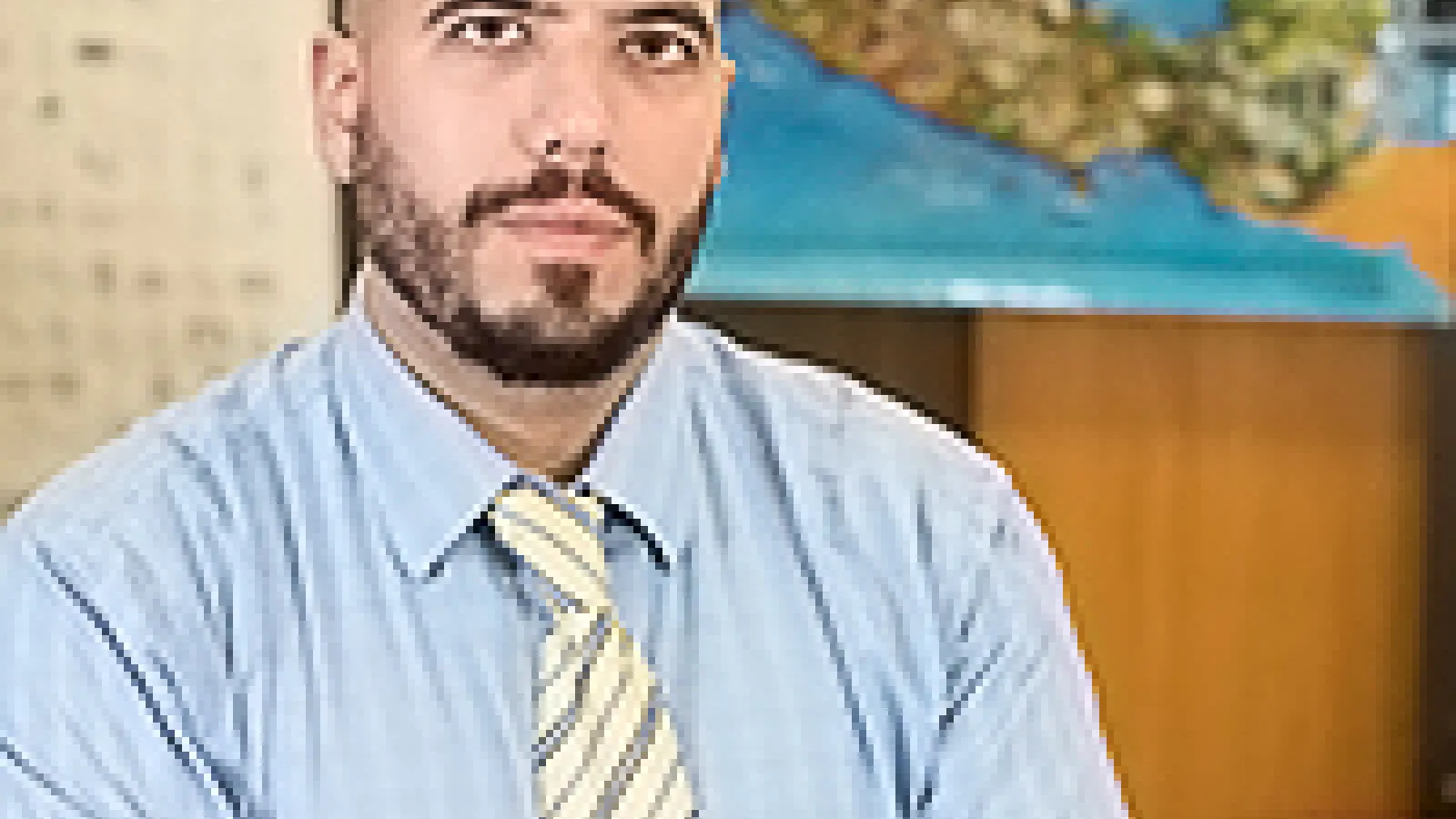 White man with arms crossed, looking at camera