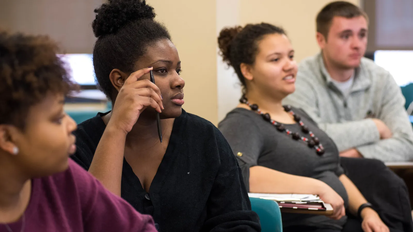 Three women listening intently to their instructor