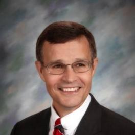 White man in suit smiling at camera