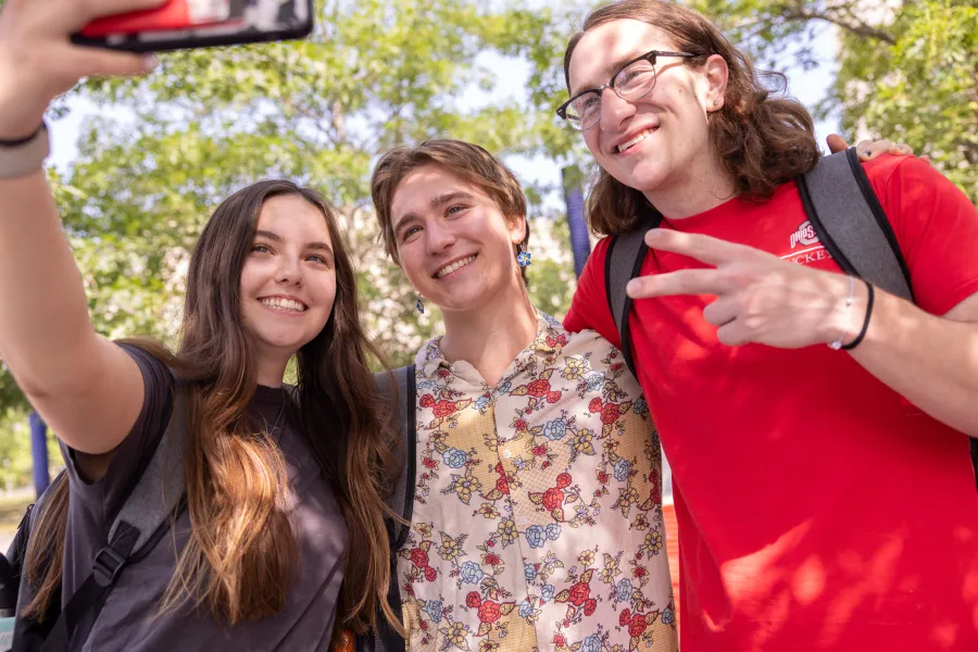 three young people posing for a selfie