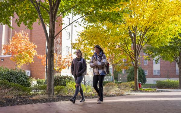 two students walking across campus in Autumn