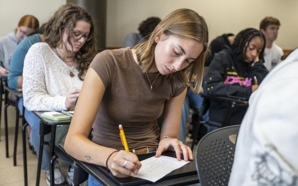 Students in class writing on paper