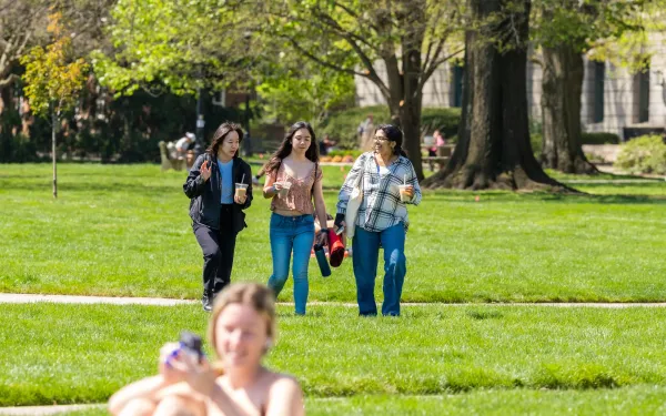 three students walking on the Oval together