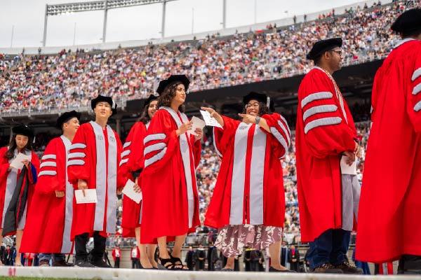 Several PhD recipients in Scarlet and Gray academic regalia at graduation in the Shoe