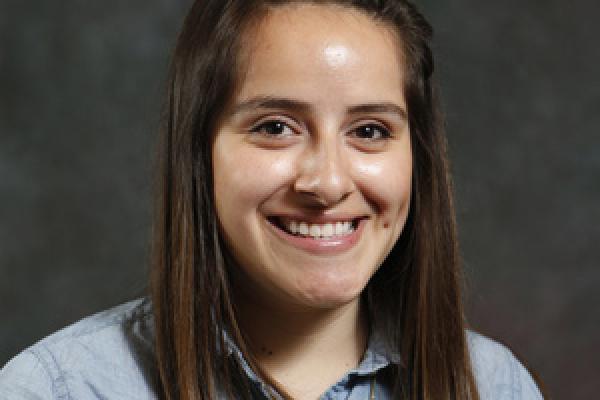 Female graduate student smiles at camera