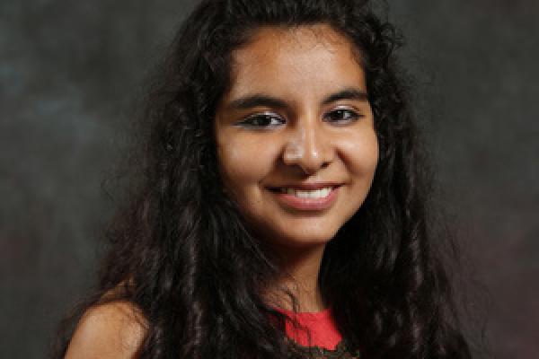 Female graduate student smiles at camera