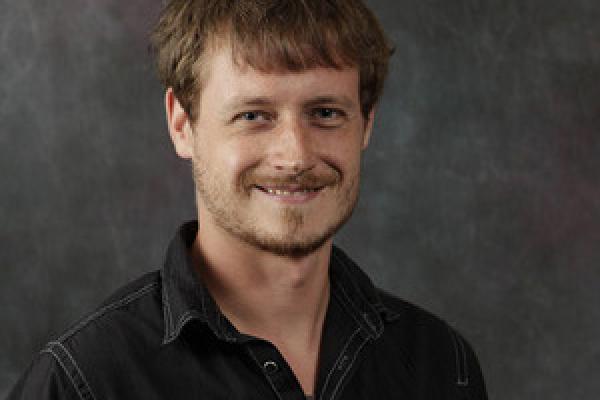 Young man with read hair, smiling at camera