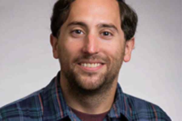 Young white man with brown hair smiling at camera