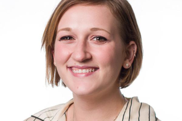 Image of white woman with blond hair, wearing a striped blouse smiling at the camera