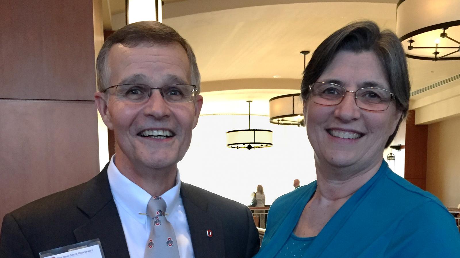 White man and white woman smile at camera