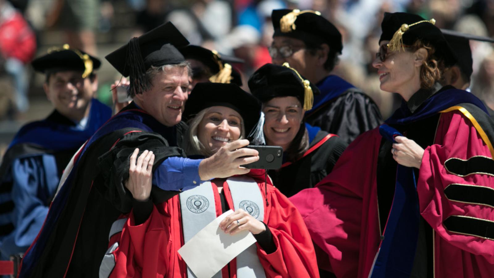 Jill Yavorsky, Vinnie Roscigno, and Rachel Dwyer  take a selfie  in the graduation line